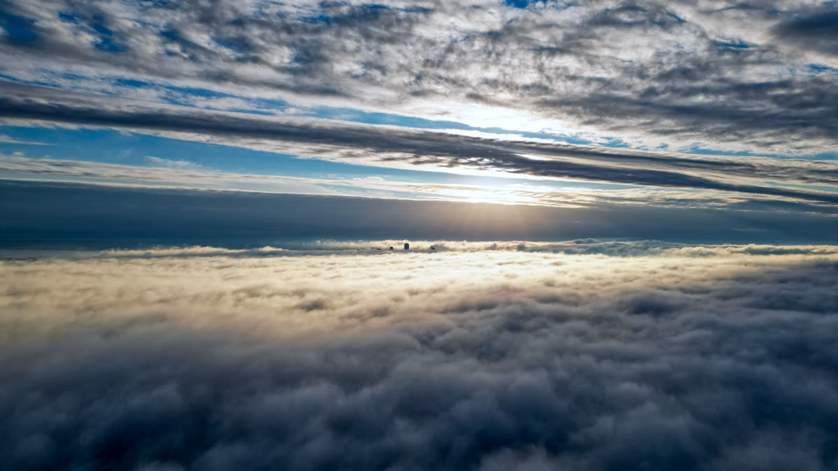Une mer de nuages éclairée par le soleil bas, vue depuis le drone au-dessus de la couche