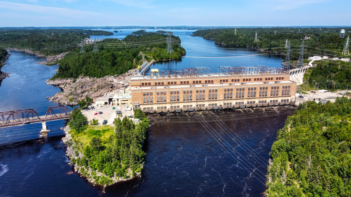 La centrale hydroélectrique d'Isle-Maligne au bord de la rivière, entourée de forêt et d'îlots
