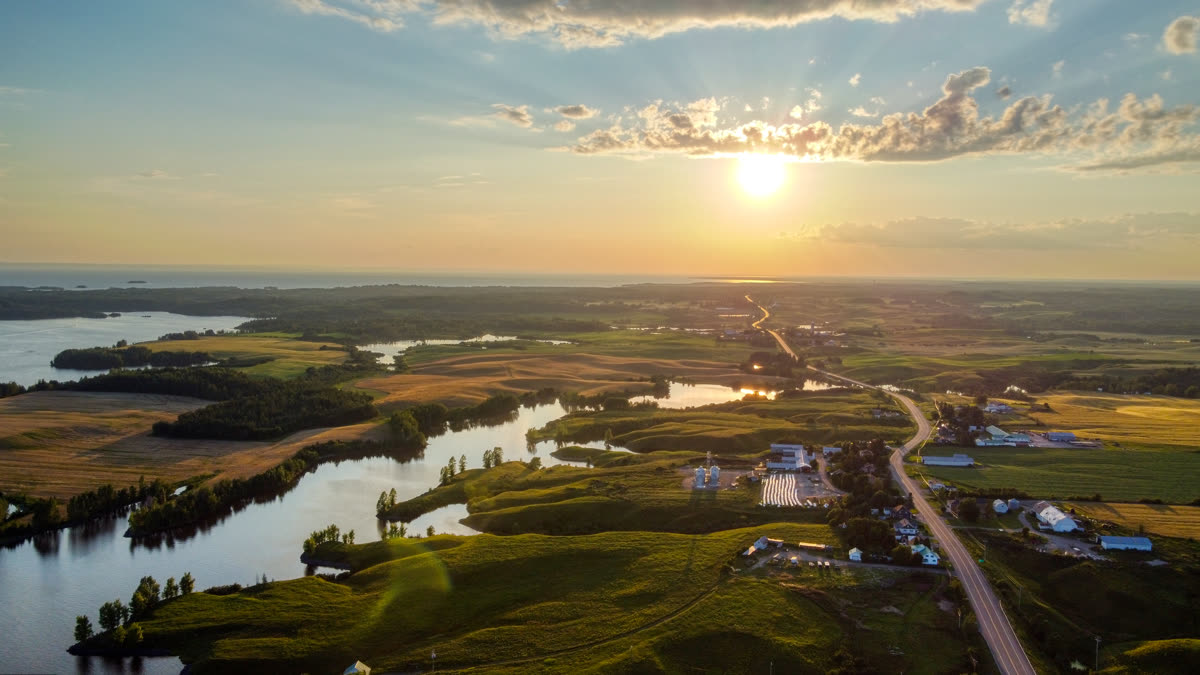 Le soleil bas au-dessus de la route de Saint-Coeur-de-Marie, entre les champs et les méandres d'eau, au Lac-Saint-Jean