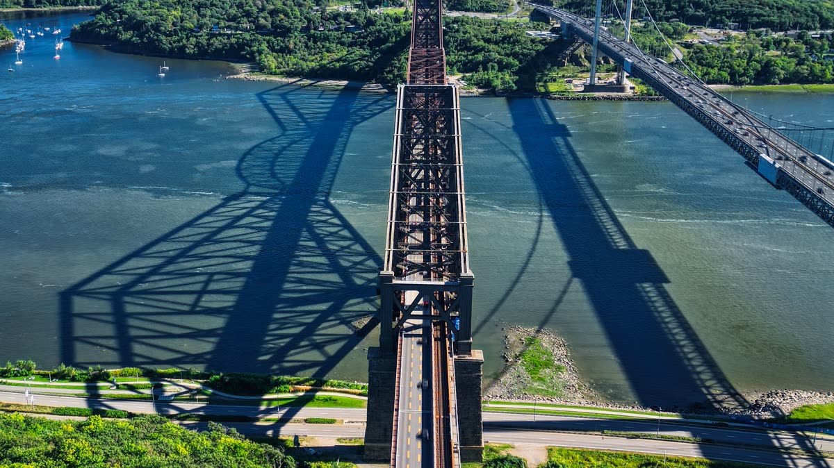 La structure d'acier du pont de Québec et son ombre portée sur le fleuve, vue de haut