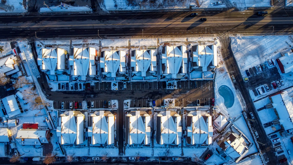 Des rangées de bâtiments aux toits clairs sous la neige, vues à la verticale