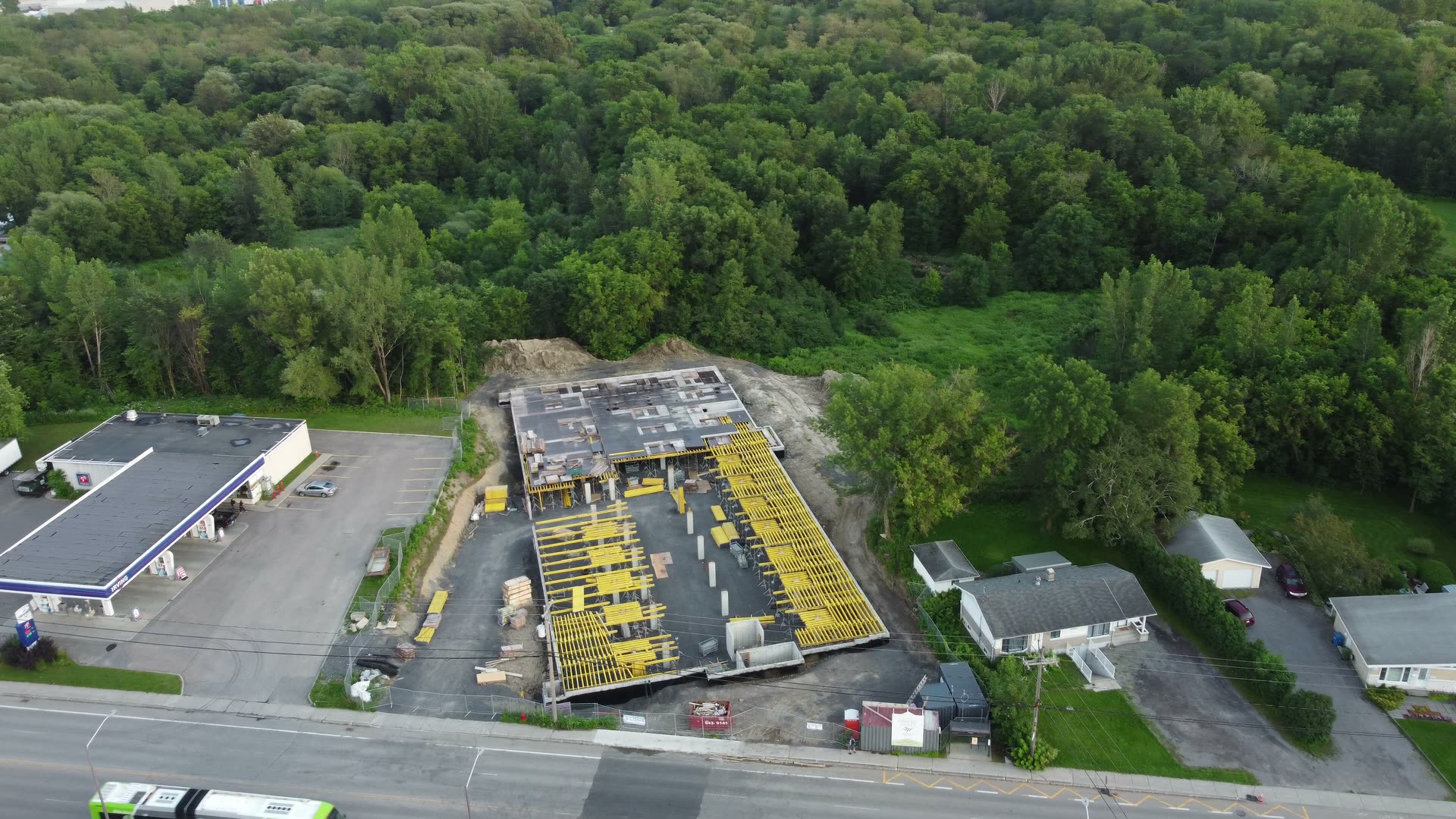 Vue aérienne d'un chantier de bâtiment aux étais jaunes, en bordure de route